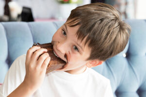 Boy eating allergen.